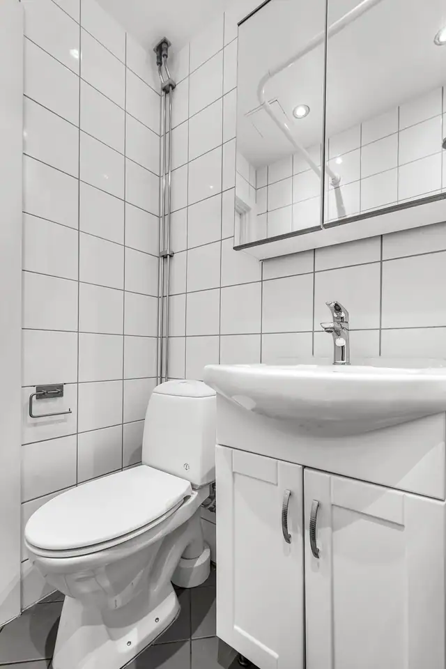 Innredning bestående av åpen dusj, servantskap, wc, naturlig avtrekk og stoppekran
