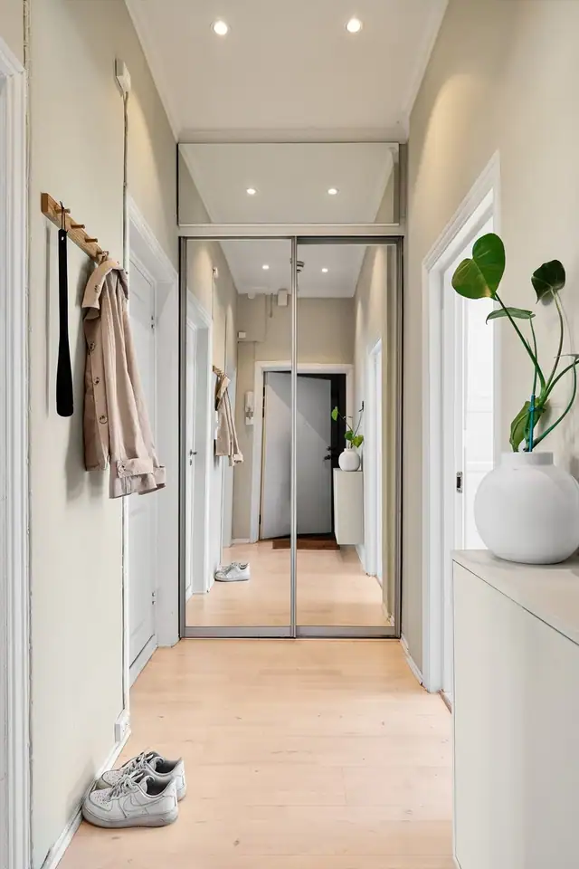 Innbydende entré som deler opp boligens øvrige rom. God plass til oppbevaring i praktisk skyvedørsgarderobe.