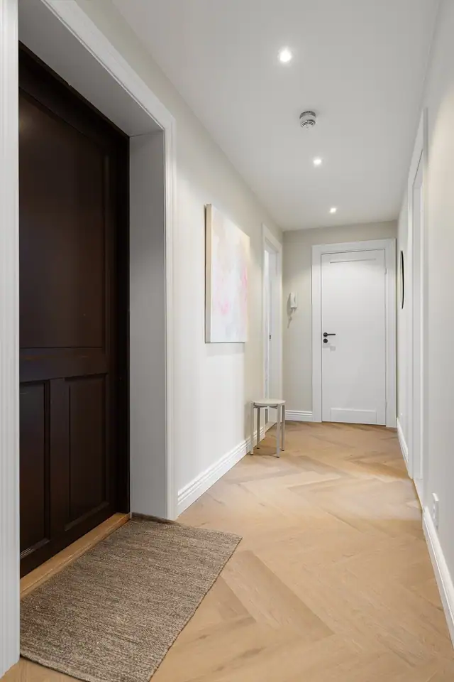 Innbydende entré som deler opp leilighetens øvrige rom. Det er montert downlights i himling.