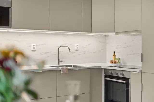 Kjøkkenet har rikelig med benke-/og skapplass, integrerte hvitevarer og pene detaljer.