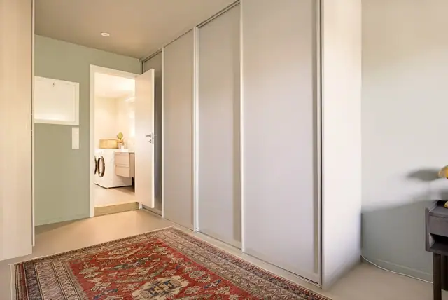 Soverommet er innredet med praktisk skyvedørsgarderobe for optimal oppbevaring. Fra soverom 1 er det også direkte adkomst til hovedbadet.